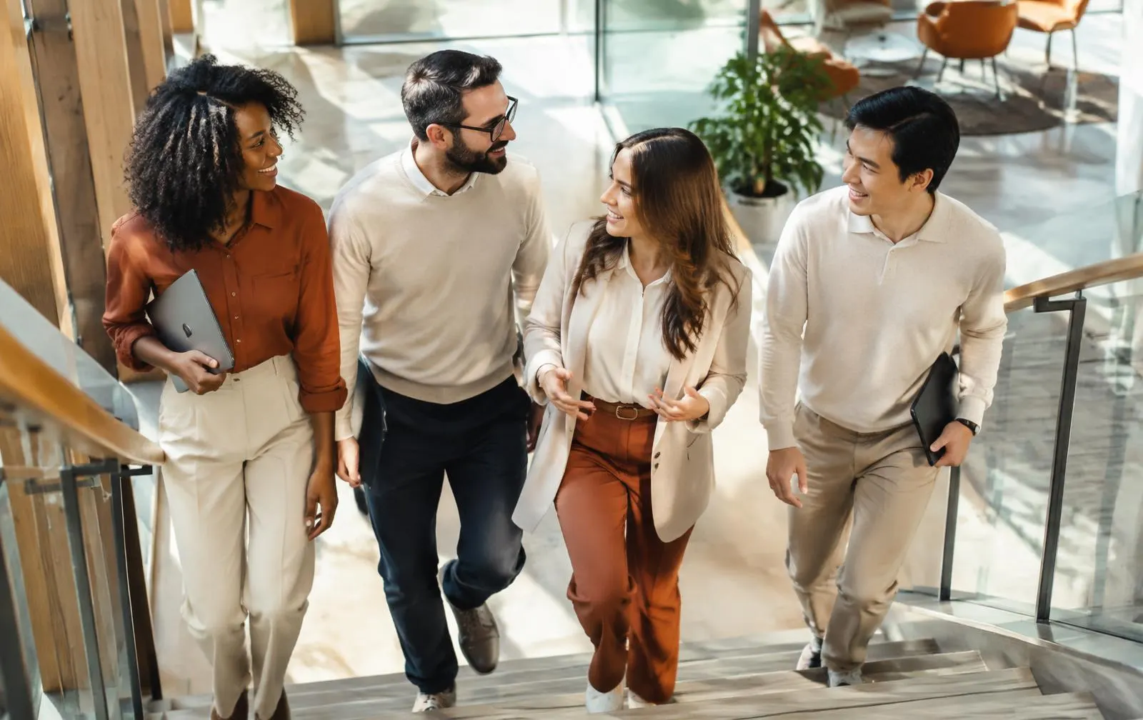 Colleagues walking up the stairs of a bright modern office atrium